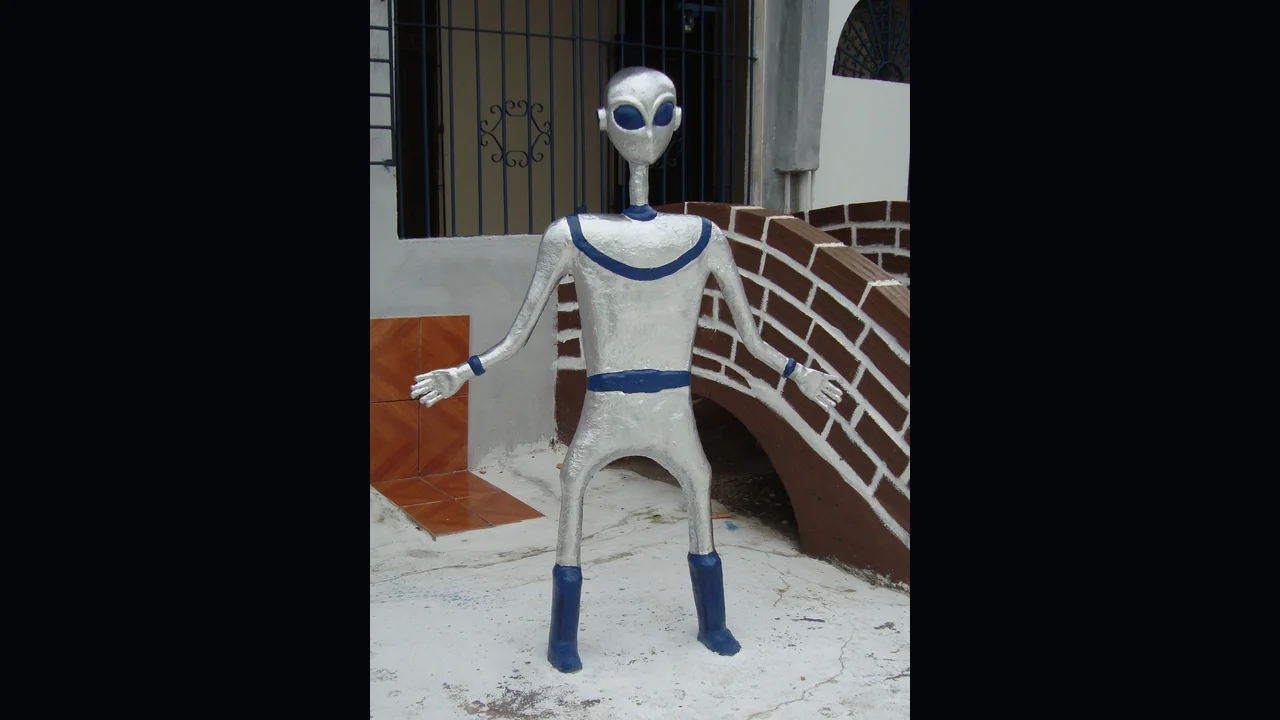 A photograph of an extraterrestrial figure displayed in Colares, Pará, Brazil — local imagery referencing the town's 1977 'chupa-chupa' UFO flap