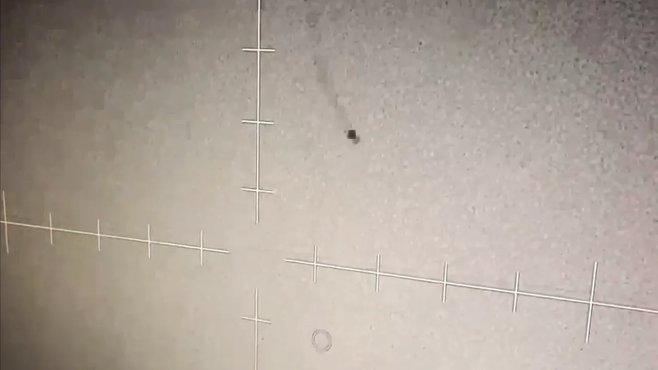 A dark, roughly square object against a bright infrared background with sensor crosshairs, filmed off an AC-130J gunship's infrared display over the Gulf of Oman in September 2021