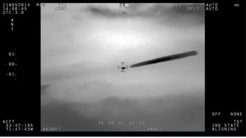 Infrared frame of a grey sky with a small dark object under the crosshair trailing a long dark diagonal plume