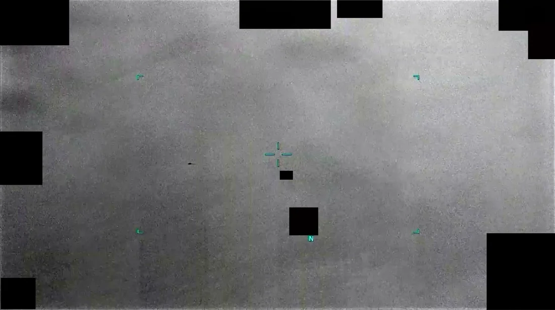 Infrared sensor frame showing a grey sky, a small dark object left of the centre crosshair, and roughly a dozen solid black rectangles covering the sensor telemetry around the edges of the display