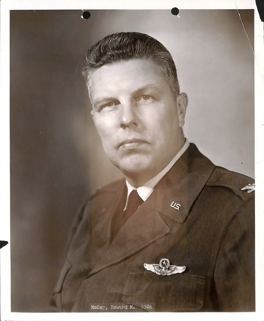 Formal black and white studio portrait of a U.S. Air Force officer in uniform with pilot wings, captioned McCoy, Howard M.
